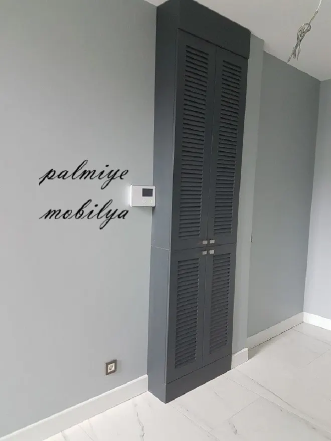 Gri duvara gömme dar, yüksek ve iki kanatlı antrasit panjur kapaklı dolap